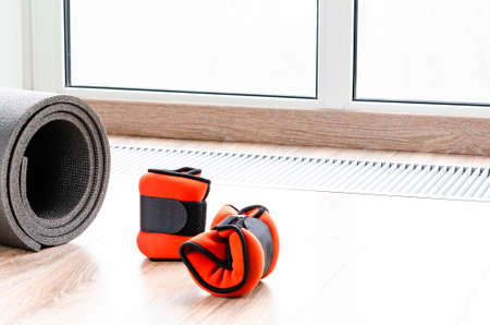 Sports concept for sports at home. Fitness mat, weights for arms and legs, harness for fitnessの写真素材