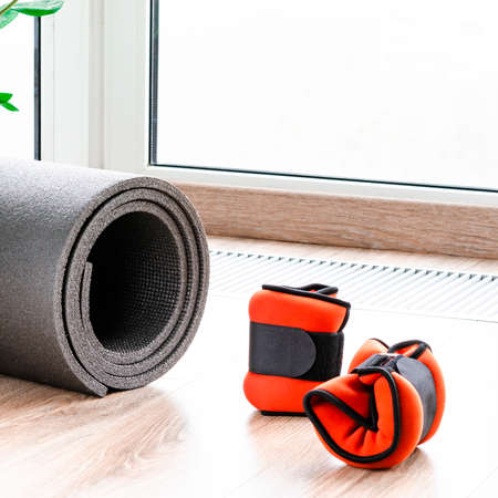 Sports concept for sports at home. Fitness mat, weights for arms and legs, harness for fitnessの写真素材