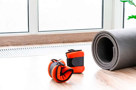 Sports concept for sports at home. Fitness mat, weights for arms and legs, harness for fitnessの写真素材