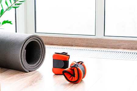 Sports concept for sports at home. Fitness mat, weights for arms and legs, harness for fitnessの写真素材
