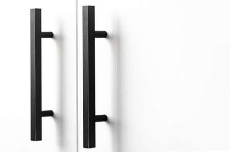white wood cupboard door by black handle. Modern kitchen furniture concept. Cozy apartment details. Closet usageの写真素材