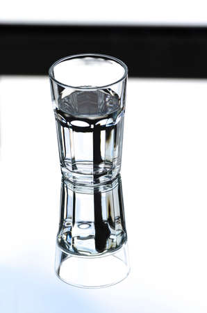 A glass with clean clear water with reflection and sharp shadows. top view.の写真素材