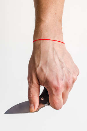 The man using folding knife. Close up folding knife in hand. EDC for men concept.の写真素材