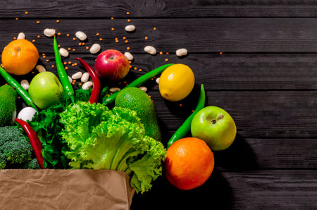 Healthy food selection. Shopping bag full of fresh vegetables and fruits. Flat lay food on tableの写真素材