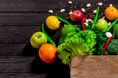 Different food in paper bag on wooden background, close up. Grocery shopping concept, top viewの写真素材