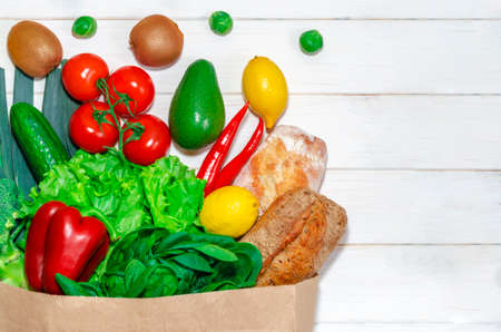 Delivery healthy food background. Vegan vegetarian food in paper bag vegetables and fruits on white, copy space, banner.Grocery shopping food supermarket and clean vegan eating concept.の写真素材