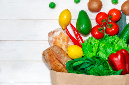 Delivery healthy food background. Vegan vegetarian food in paper bag vegetables and fruits on white, copy space, banner.Grocery shopping food supermarket and clean vegan eating concept.の写真素材