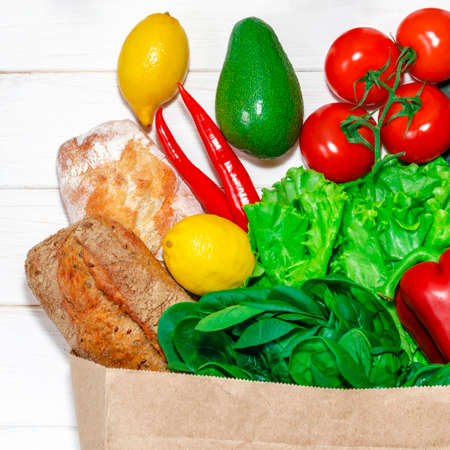 Paper bag of different health food on white wooden background. top view. flat layの写真素材