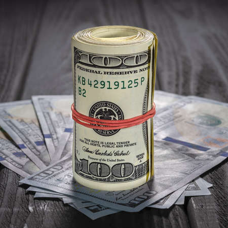 Highlight for the hundred dollar bill. roll of dollars with red rubberの写真素材