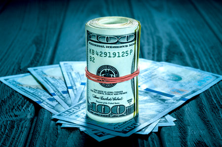 Highlight for the hundred dollar bill. roll of dollars with red rubberの写真素材