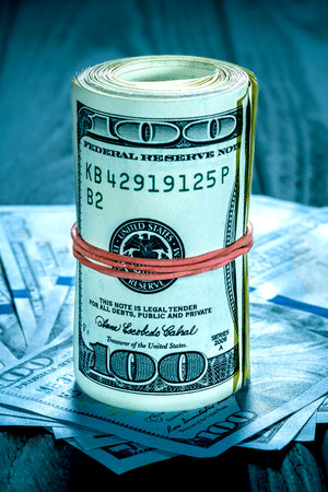 Highlight for the hundred dollar bill. roll of dollars with red rubberの写真素材