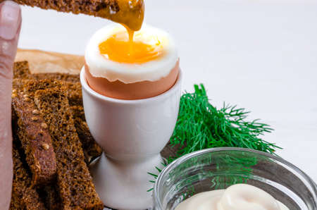 Health food. English breakfast with boiled egg and croutons on a white wood backgroundの写真素材