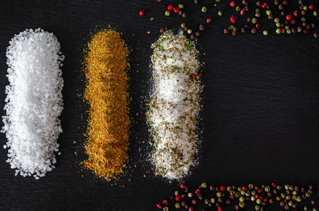 variety of natural and spicy salt on black tableの写真素材