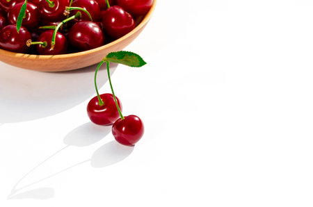 cherry. Ripe red cherry with green leaves lies on a white backgroundの写真素材