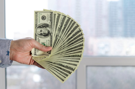 dollars in the hands. Businessman in blue shirt holding dollarsの写真素材