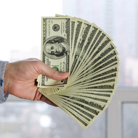 dollars in the hands. Businessman in blue shirt holding dollarsの写真素材