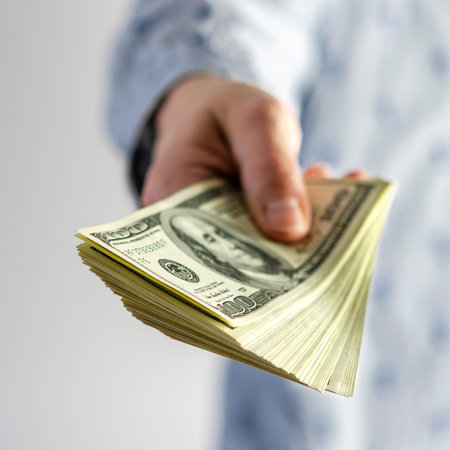 A man hands over a thick wad of dollars. bribeの写真素材