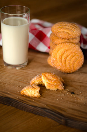 Round homemade cookies and a glass of homemade milk on a wooden trayの写真素材