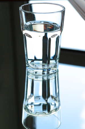 Reflection of a glass of spring water in the mirror. reflectionの写真素材
