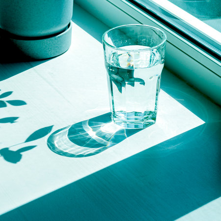 sharp shadows. A glass of pure spring water and sharp shadowsの写真素材