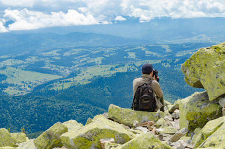 A tourist with a camera on top of a mountain. Hikingの写真素材