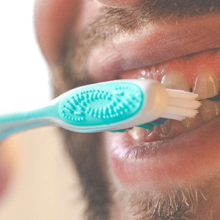 Personal hygiene. Man brushing his teeth with a toothbrushの写真素材