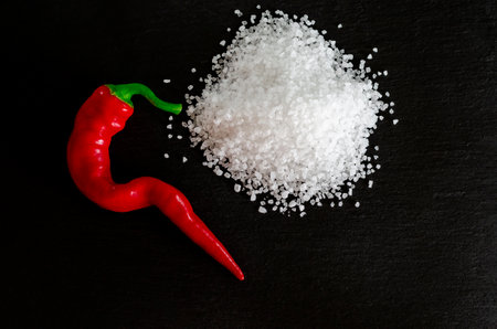 Mexican hot pepper and coarse salt on a black stone. spicy