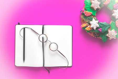 White notebook, round glasses and black pencil on bright background. Christmas Contentの写真素材