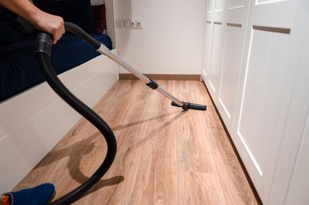 Cleaning content. A man is pee-licking the floor in an apartment. Cleaning of home and officeの写真素材