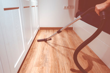 Cleaning content. A man is pee-licking the floor in an apartment. Cleaning of home and officeの写真素材