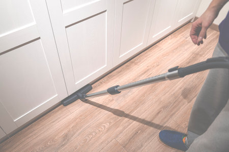 Cleaning content. A man is pee-licking the floor in an apartment. Cleaning of home and officeの写真素材