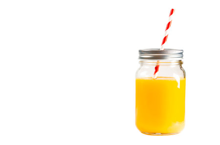 Fresh orange juice. A Glass jar of orange juice with a multi-colored tube.の写真素材