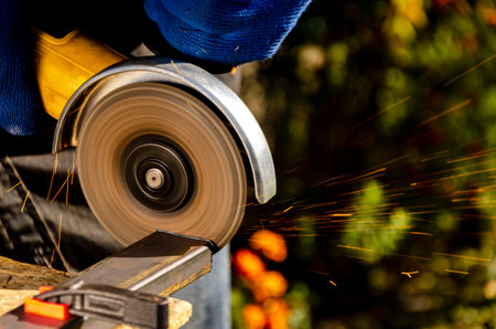 Working with metal. Disc power tool grinder in the hands of a man.の写真素材