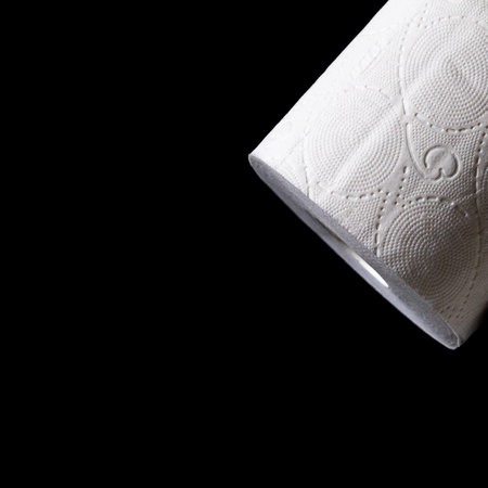 Roll of white toilet paper on a black backgroundの写真素材