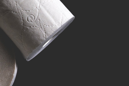 Roll of white toilet paper on a black backgroundの写真素材