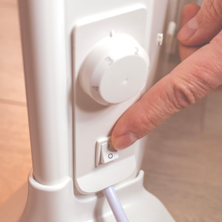 Energy saving. Switch off button of the electrical appliance. Finger on the button close-upの写真素材
