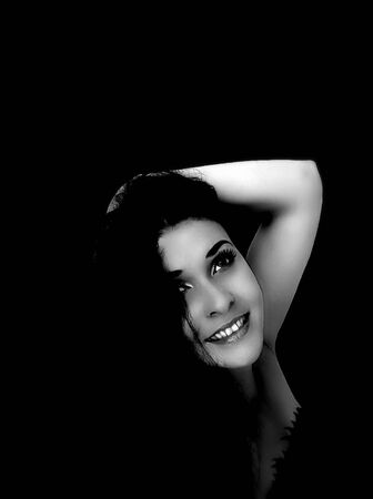 Portrait of a smiling brunette on black backgroundの写真素材