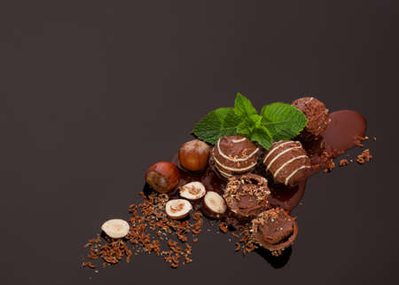 Round chocolate candies with a soft filling scattered in the lower right corner with chocolate...