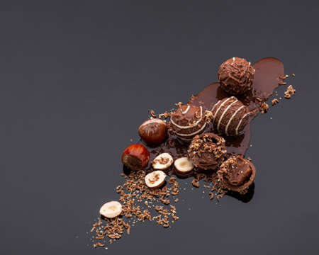 Round chocolate candies with a soft filling scattered in the lower right corner with chocolate...
