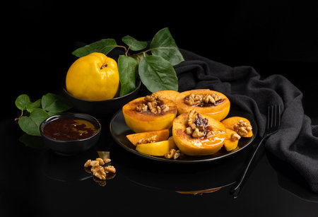 ripe yellow quince fruits on a black dish. on a black backgroundの写真素材