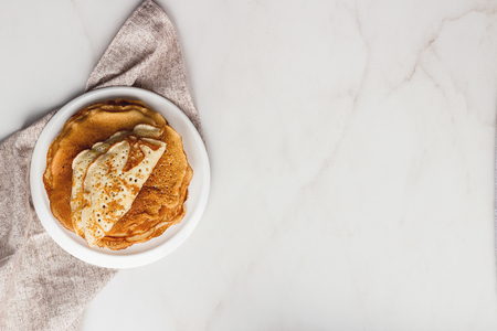 Golden wheat pancakes or crepes in a white plateの写真素材