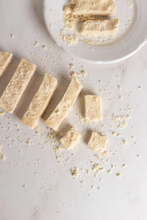 Sliced halva on the white table.