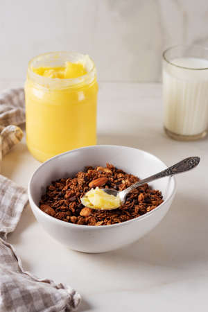 Homemade chocolate granola with ghee and milk on a light background. Healthy breakfastの写真素材