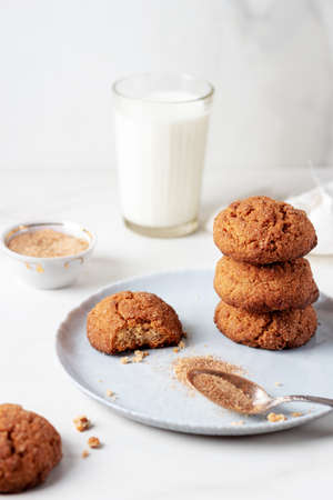 Freshly Homemade baked ginger cookies with cinnamon and sugar on gray plate and glass of milk, light...
