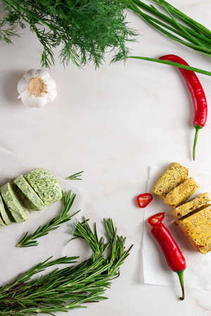 Homemade butter with herbs, rosemary, garlic, onions and butter with papper on marble backgroundの写真素材