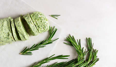 Homemade butter with herbs and rosemary for sandwiches and steak sliced on marble background.の写真素材