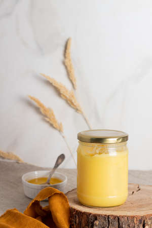 Indian ghee clarified butter desi in glass jar on wood slice.の写真素材