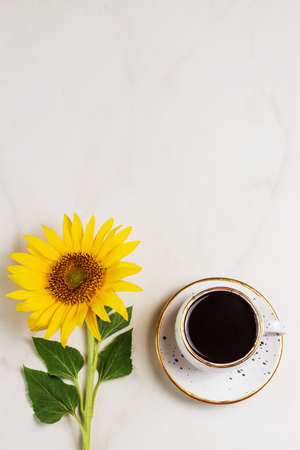 Cup of coffee with sunflowers with space for text on marble background. Copy spaceの写真素材