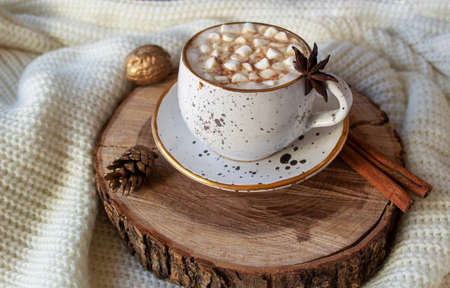 A cup of hot chocolate with marshmallows on wooden saw cut. Christmas cozy composition.の写真素材