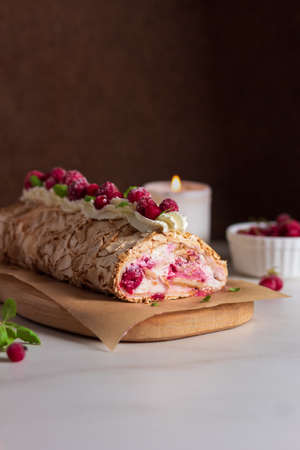 Meringue roll cake with berries whipped cream and Coffe over a dark background. Summer dessert. Dark photo.の写真素材